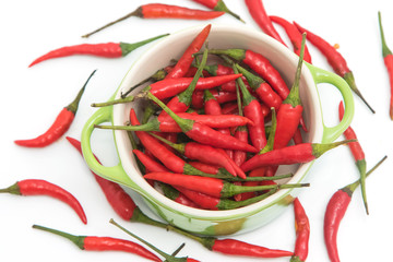 red chili pepper in green bowl isolated on a white background