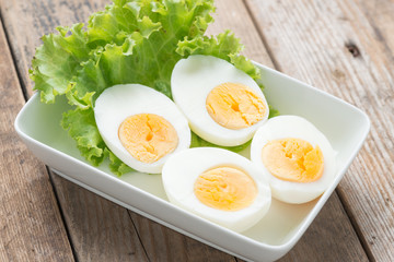 Sliced boiled eggs on white plate.