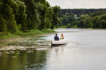 Fototapeta na wymiar жених и невеста в белой лодке на озере