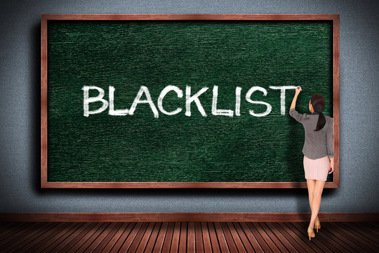 Businesswoman drawing blacklist  on chalkboard