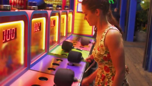 Two friends play a carnival arcade game
