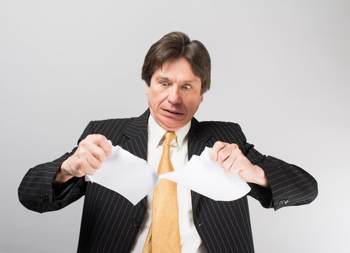 businessman tears the paper
