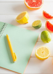 citrus with notebook on white wooden table