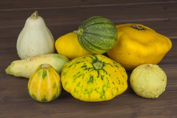 Autumn harvest of pumpkins. Preparing for Halloween. Growing vegetables in a home garden. Place for your text. Autumn pumpkins with leaves on wooden board

