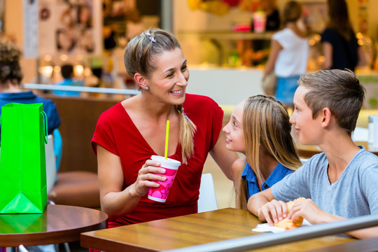 Familie isst im Cafe in Kaufhaus oder Einkaufszentrum