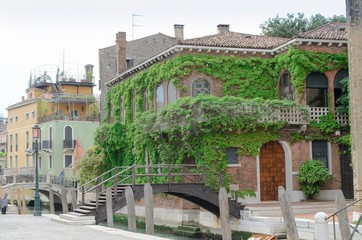 Typical venetian villa with bricks creepers and iron bridge, Venice