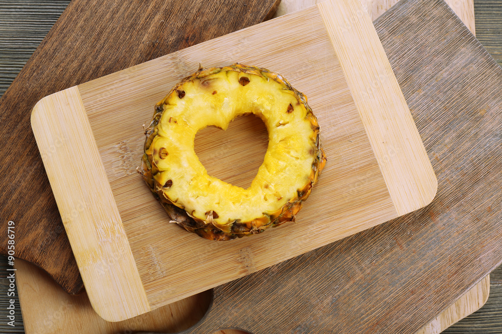 Poster Pineapple slice with cut in shape of heart on wooden background