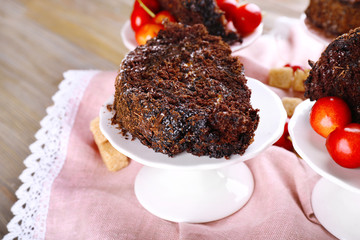 Delicious chocolate roll in saucer on wooden table with napkin, closeup