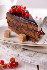 Tasty chocolate cake with berries on table close up