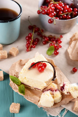 Tasty cheesecake with berries and cup of tea on table close up