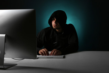 Hacker with computer on colorful dark background