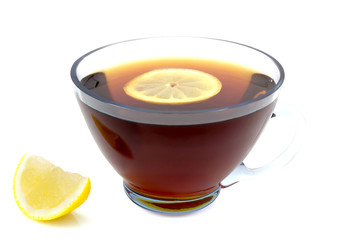 transparent cup of tea with a slice of lemon and whole lemon left isolated on white background
