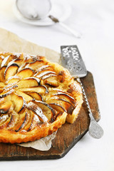 Homemade apple pie on cutting board on white wooden table background background