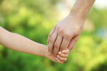 Father and daughter hands outdoors