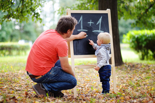 Father and his toddler son practicing mathematics