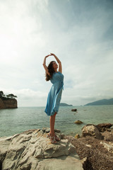 Fototapeta na wymiar Young happy woman posing near sea