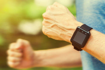 Runner with smart watch outside in nature
