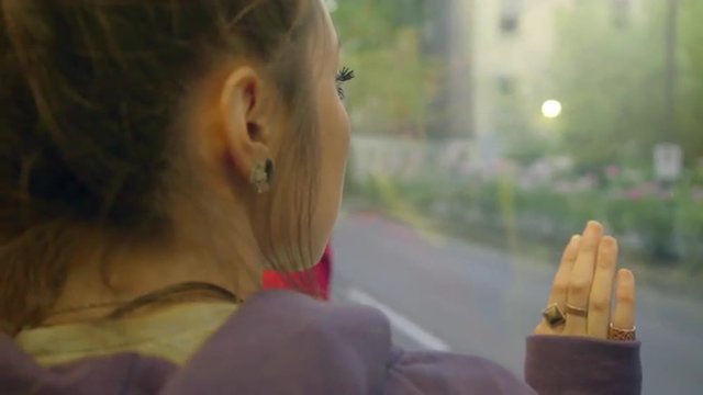 Girl looks out train window deep in thought
