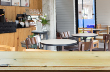 Selected focus empty brown wooden table and Coffee shop blur bac