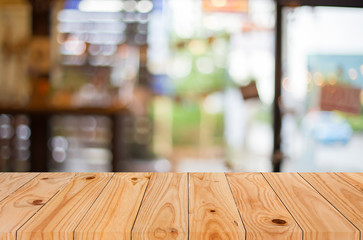 Selected focus empty brown wooden table and Coffee shop blur bac