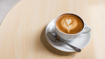 Hot art Latte Coffee in a cup on wooden table