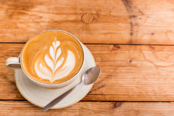 Hot art Latte Coffee in a cup on wooden table.