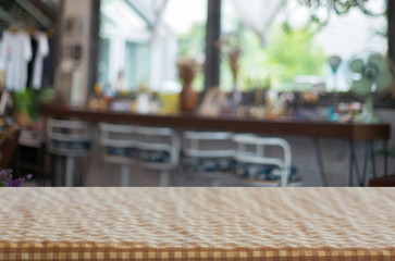 checkered table cloth on empty table and restaurant or cafe for