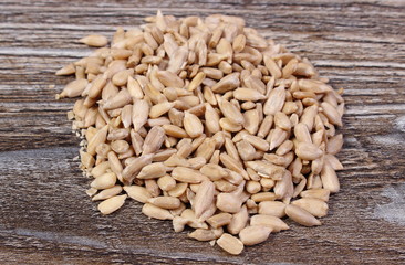 Heap of sunflower seeds on wooden background