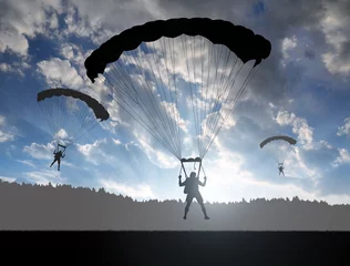 Photo sur Plexiglas Sports aériens Silhouette skydiver parachutist landing at sunset