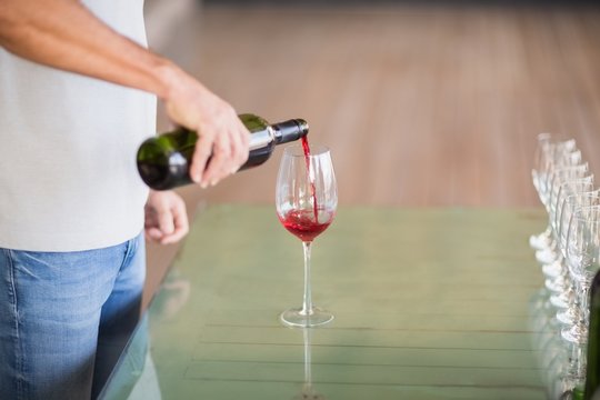 Sommelier pouring red wine in wineglass