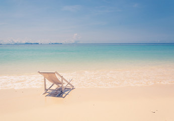 beach chair on beach with blue sky - soft focus with film filter
