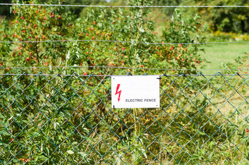 Electric fence with warning sign to prevent shock