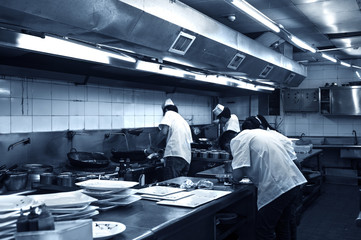 Obraz premium Crowded kitchen, a narrow aisle, working chef.