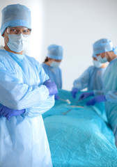 Team of surgeon in uniform perform operation on a patient at