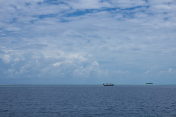 Seascape with boat and cloudy sky