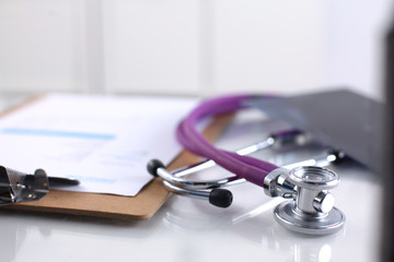 A medical stethoscope near a laptop on a wooden table, on white