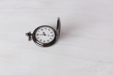 Classic pocket watch on grune white wooden background