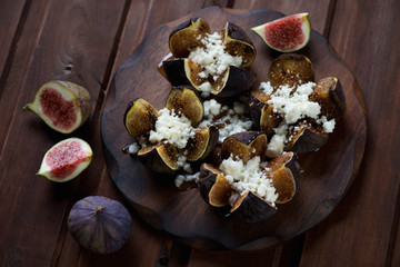 Obraz na płótnie Canvas Baked figs with cottage cheese and honey, dark wooden background