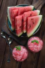 Watermelon granita and fresh watermelon slices in the background