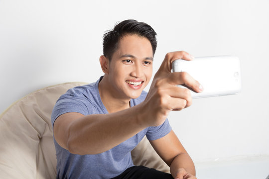 young attractive man taking pictures of him self (selfie) with s