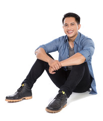Naklejka premium Young asian man sitting on the floor, smile