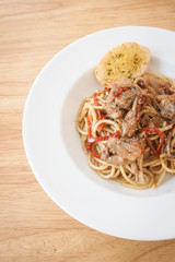 Spaghetti, spicy chicken.on wood table