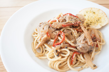Spaghetti, spicy chicken.on wood table