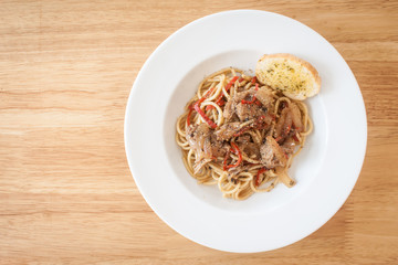 Spaghetti, spicy chicken.on wood table