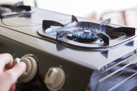 Hand switching a knop on a stove, close up