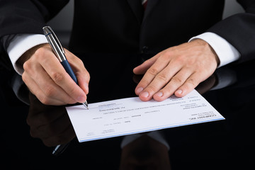 Businessperson Signing Cheque