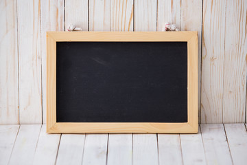 Black chalkboard hanging on wooden dark background, horizontally