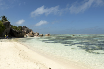 Paradise beach of Seychelles in la Digue island, Anse Source d'Argent. Boulders black granite rocks, tropical vegetation, turquoise water, white sand and blue sky.