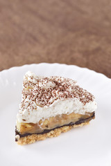 Banoffee wipe cream cake in soft light and selective focus