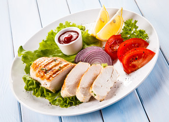 Grilled chicken fillet and vegetables on white background 